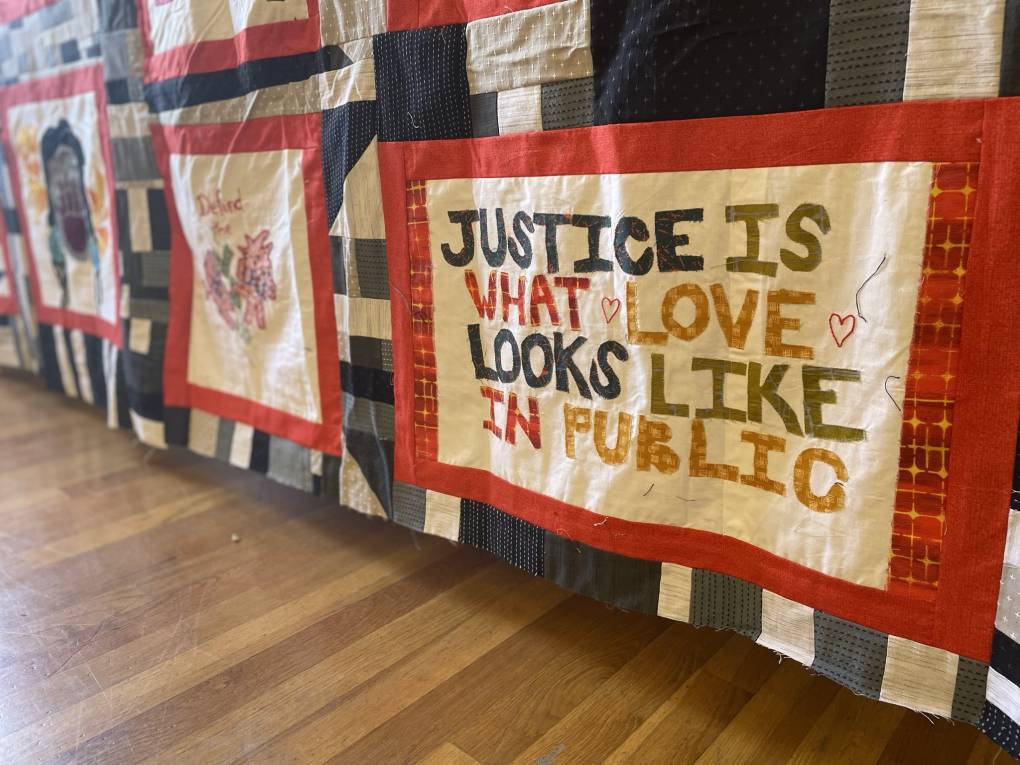 A community quilt that reads 'justice is what love looks like in public'
