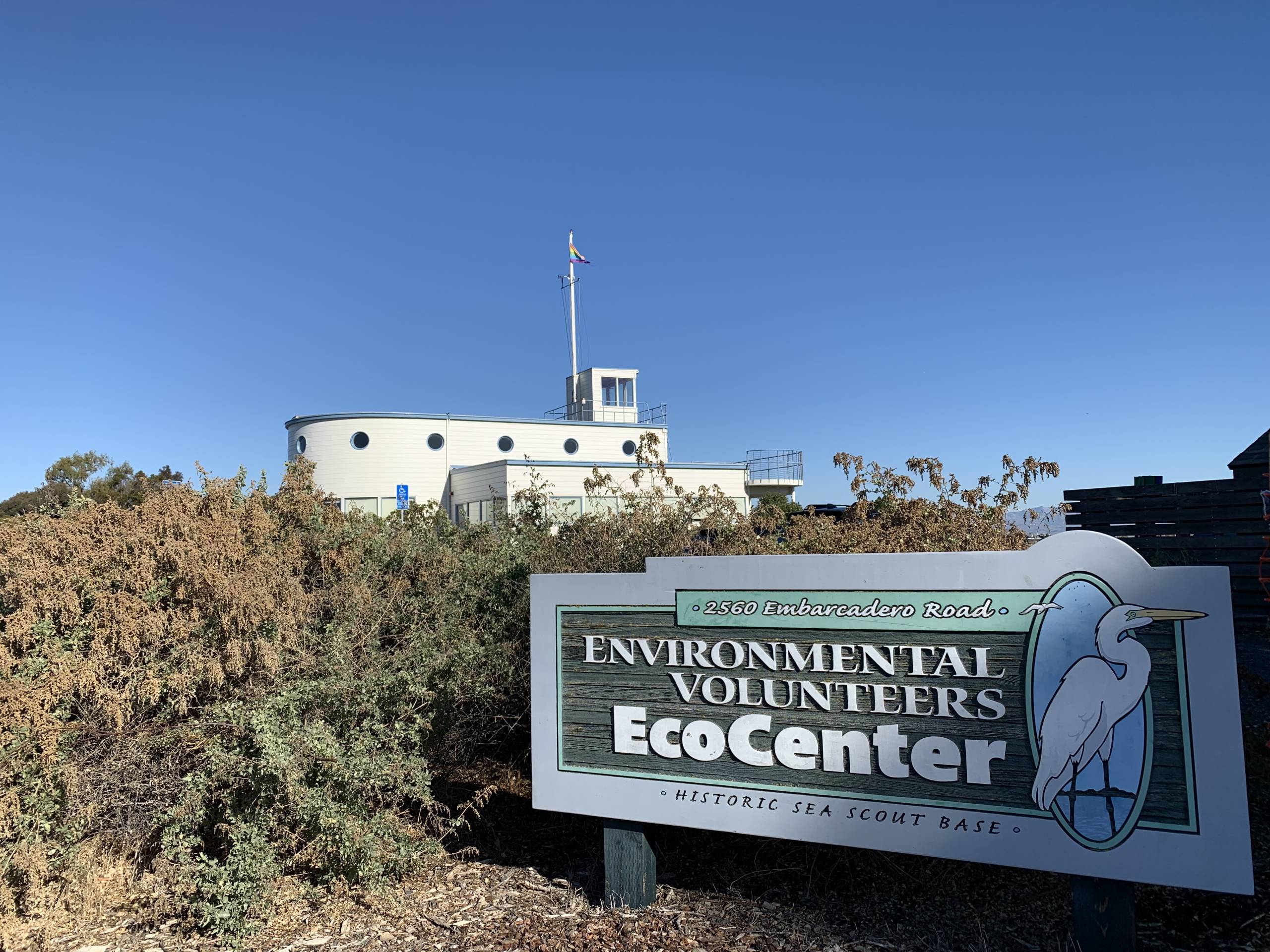 A big sign by a building that looks like a boat says "Environmental Volunteers EcoCenter."