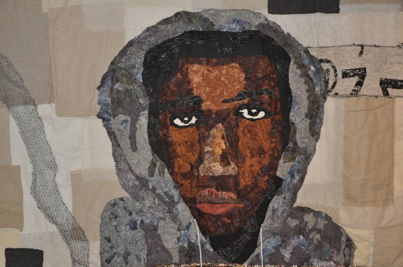 A quilt image of a black youth with a gray hoodie.