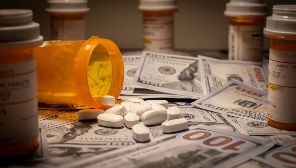 Prescription medication is strewn out upon US currency.