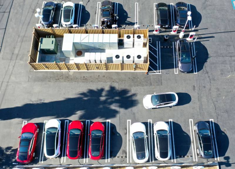 An aerial view of a car parking lot with charging stations.