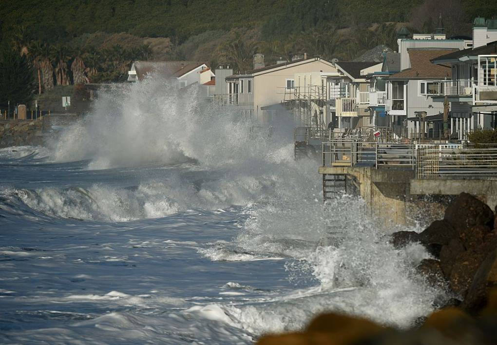 Waves crashing onto seaside houses.