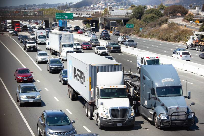 View of a freeway with cars and trucks.