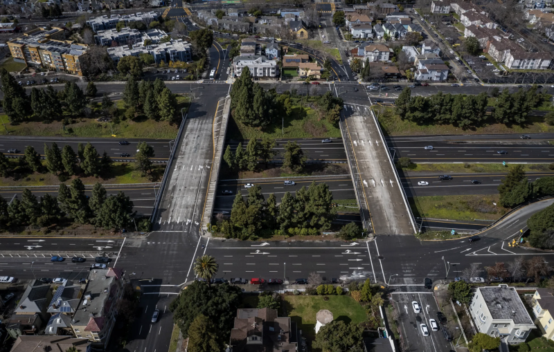 An aerial view of a freeway and residential buildings.