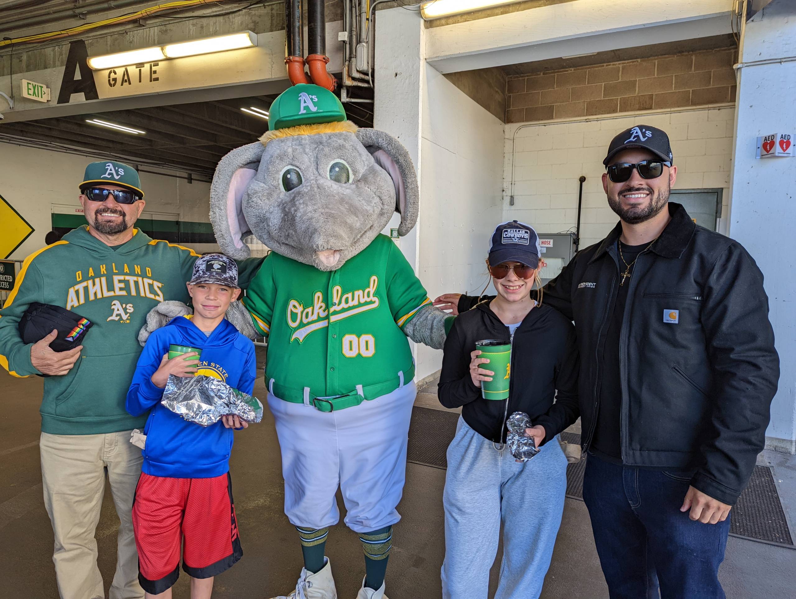 A family of four stand with Oakland A's mascot Stomper.