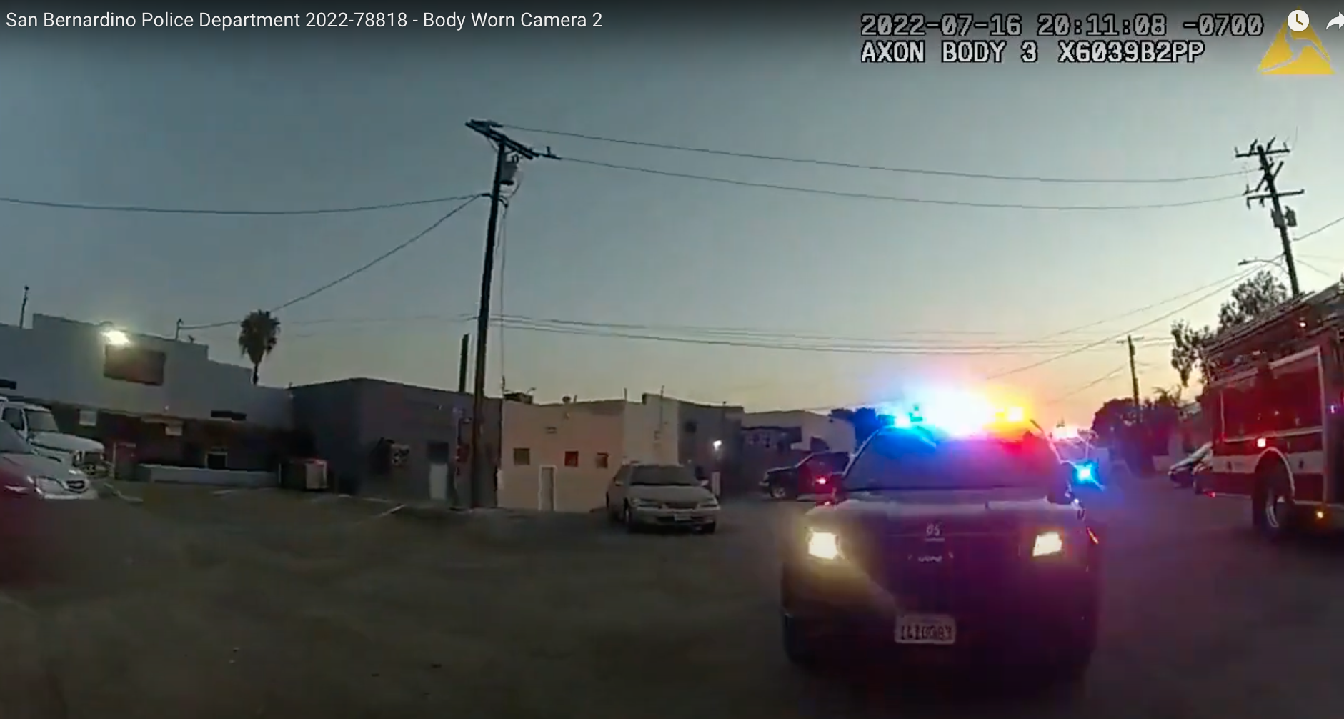 A still shot from police dash cam footage shows a police vehicle with red and blue lights flashing as it answers a call in a neighborhood in Southern California.