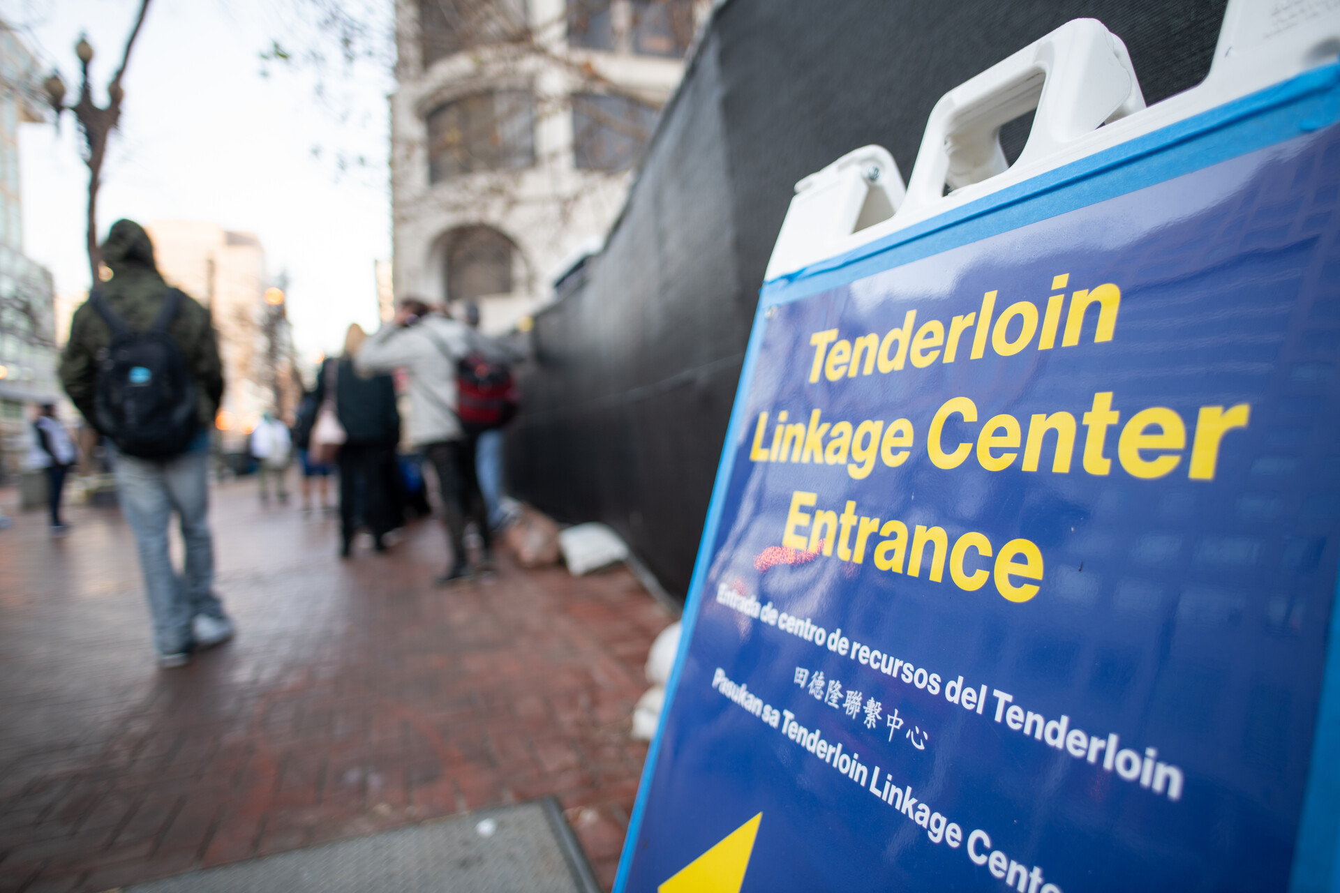 A blue and yellow sign reads, "Tenderloin Linkage Center Entrance."