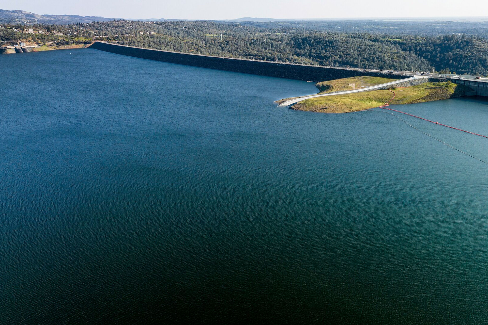 Areal view of water being held back by a dam.