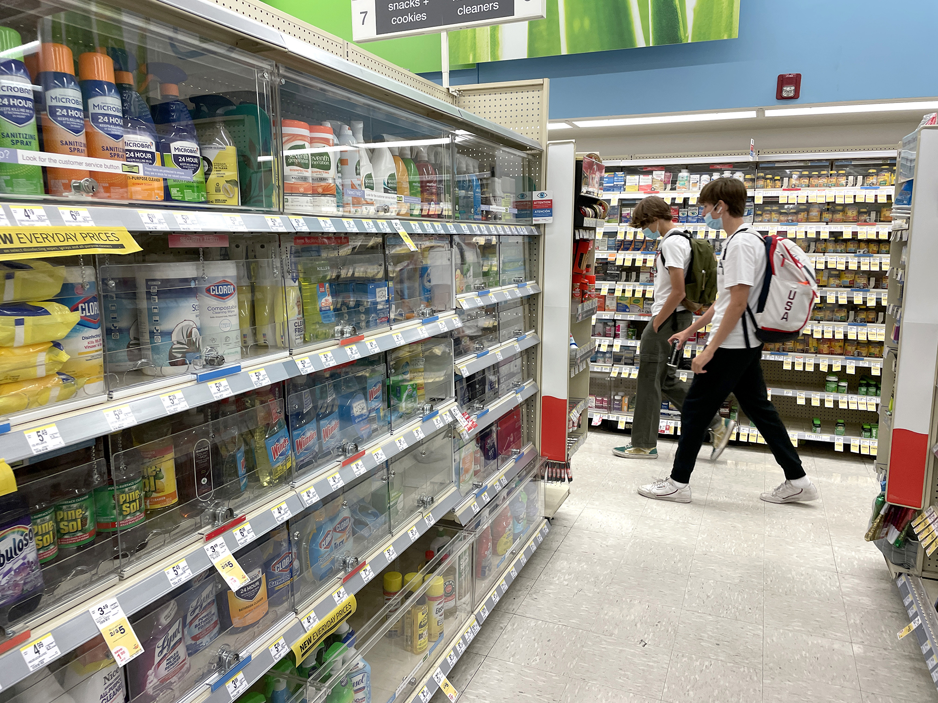 An entire aisle of goods locked behind plexiglass cabinets. 
