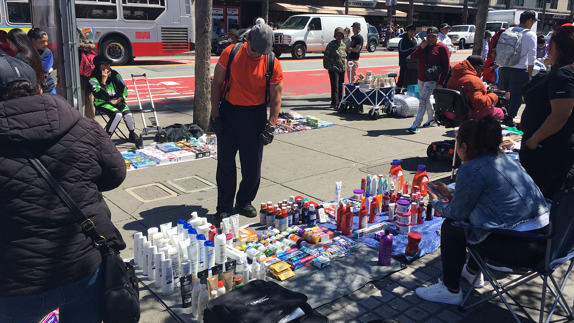 A blanket laid out on Market Street in San Francisco has shampoos, soaps, and other toiletries neatly lined up.