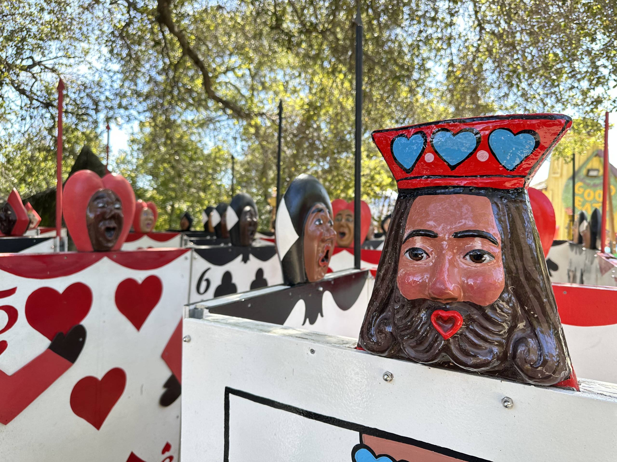 A view of the anthropomorphic playing cards from Alice in Wonderland, arranged side-by-side to form a maze. Each red or black playing card has a flat head at the top, with various skin tones and facial expressions (although most look surprised).