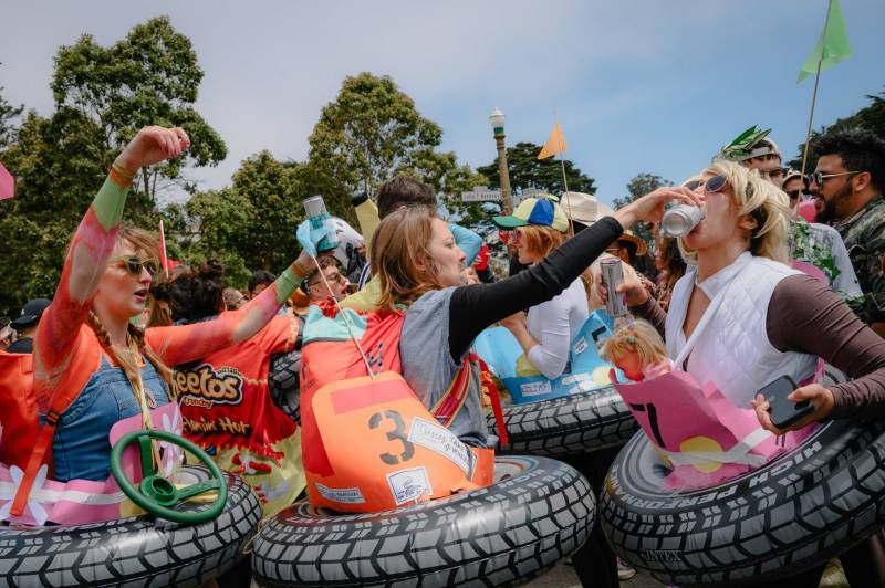 A group of people partying while in costume. They are wearing inflatable innertubes designed to look like car tires, with small fake steering wheels attached.