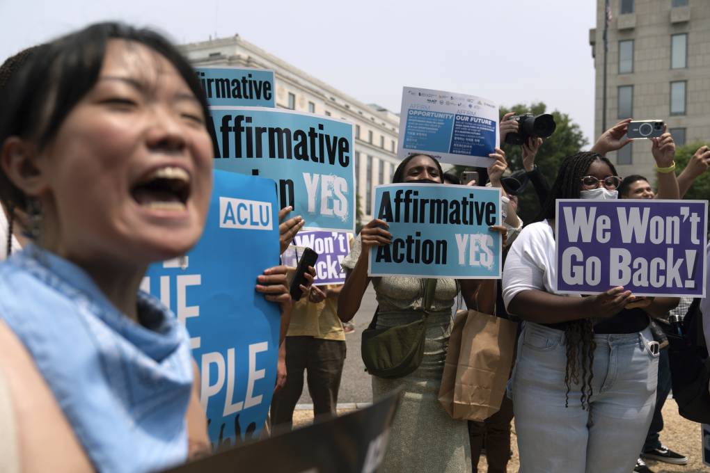Supporters of affirmative action hold signs and rally in front of the U.S. Supreme Court. One sign says: 'We won't go back.'