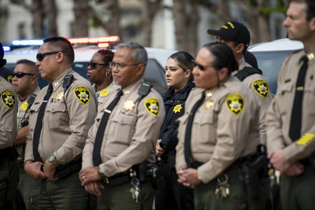 San Francisco Sheriff's Department stand next to each other as they listen to a press conference.