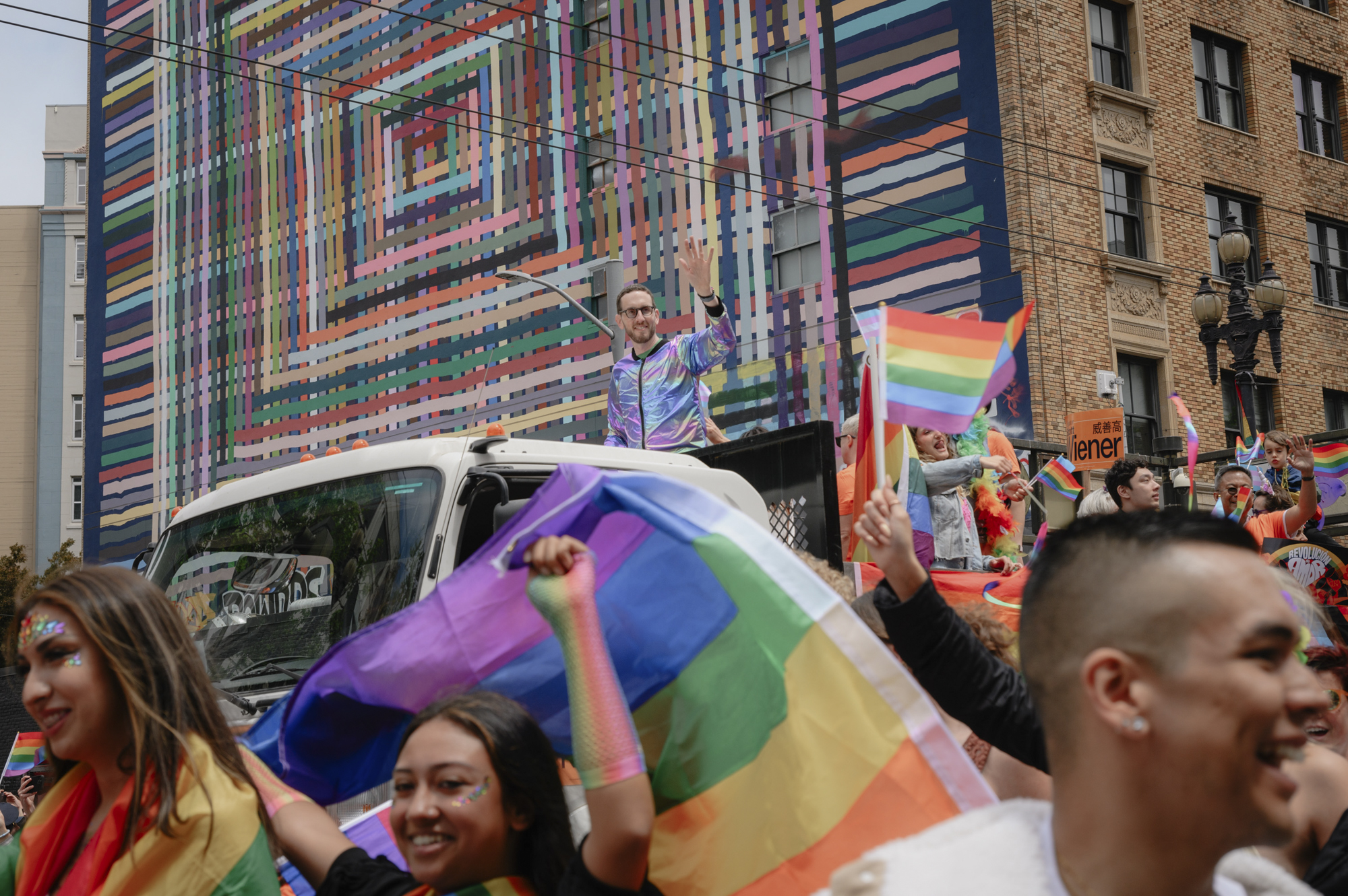 State Senator Scott Weiner waves to onlookers from atop a truck as the Pride parade passes down Market Street in downtown San Francisco on June 25, 2023.