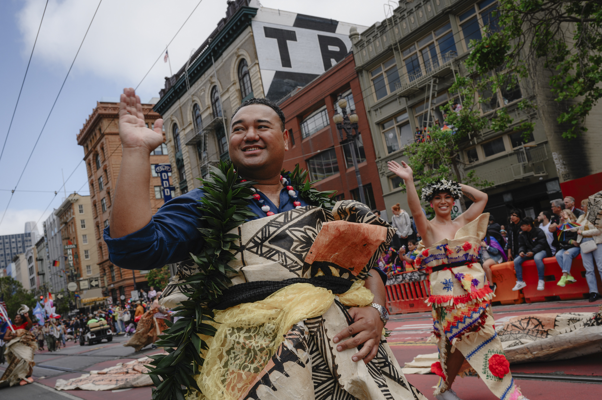 Henry Aho, 34, waves to onlookers as the Pride parade passes down Market Street in downtown San Francisco on June 25, 2023.