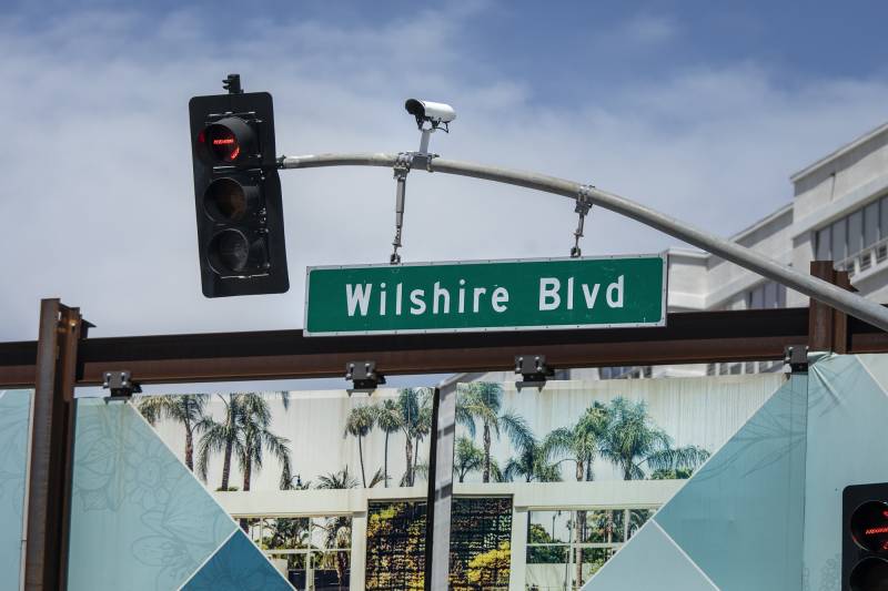 A traffic light, sign and surveillance camera.