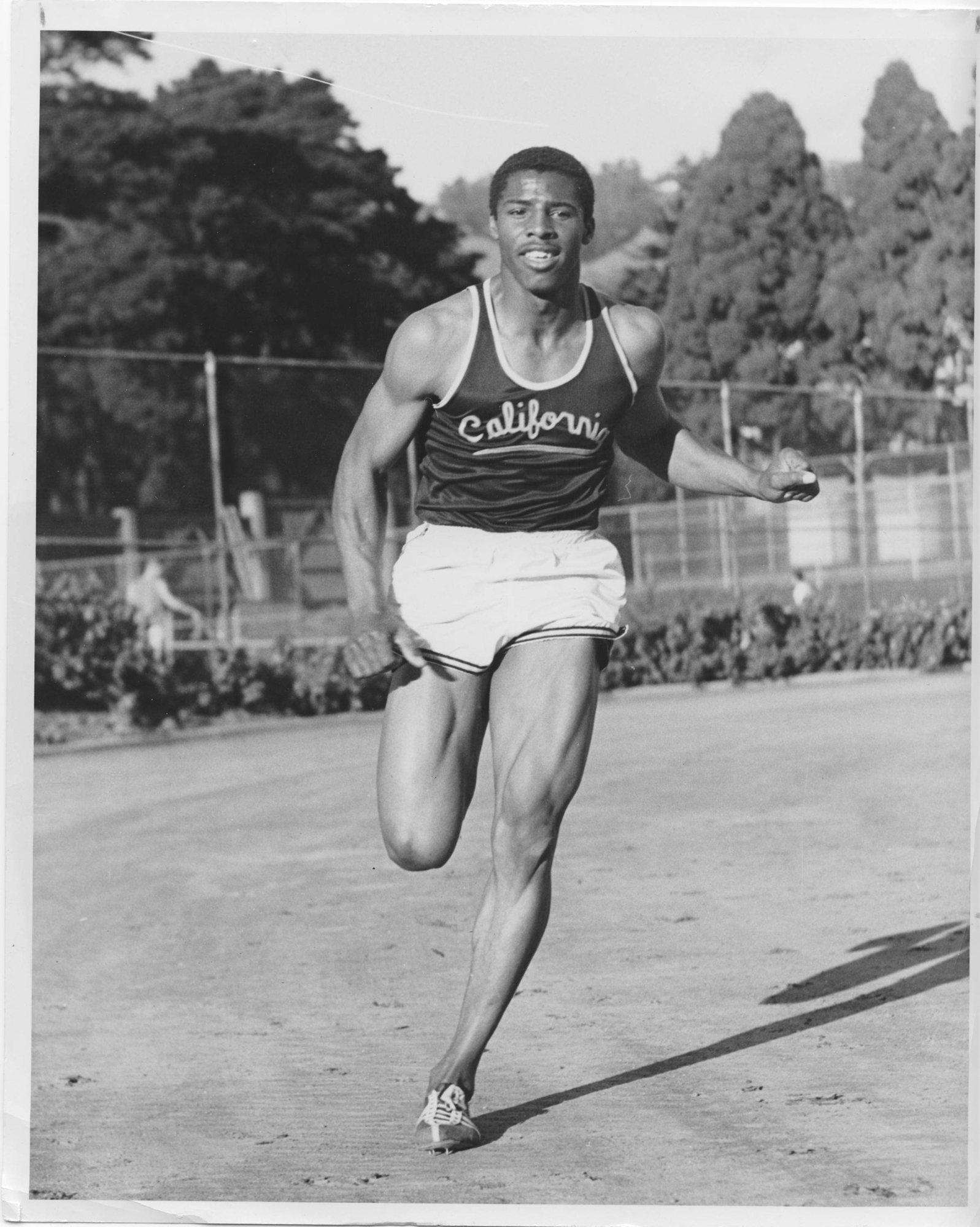 A man runs on a track with the word "California" written on his shirt.