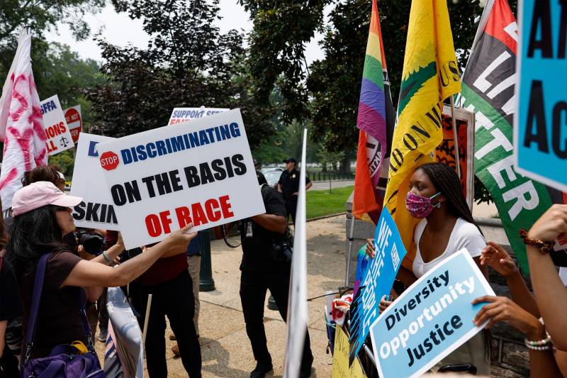 Opposing protestors clash at a rally about the Supreme Court's ruling on affirmative action. One side of demonstrators hold signs that read, "Stop Discriminating on the Basis of Race," while others hold signs that read, "Diversity Opportunity Justice."