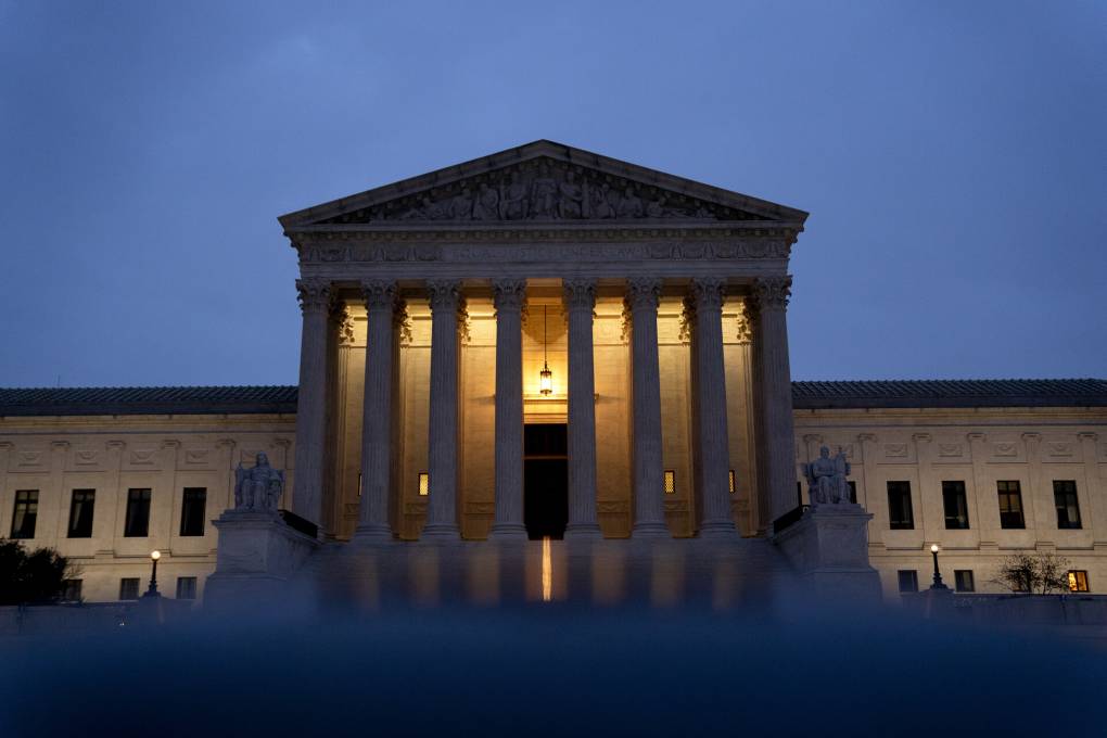 The Supreme Court building photographed at night.