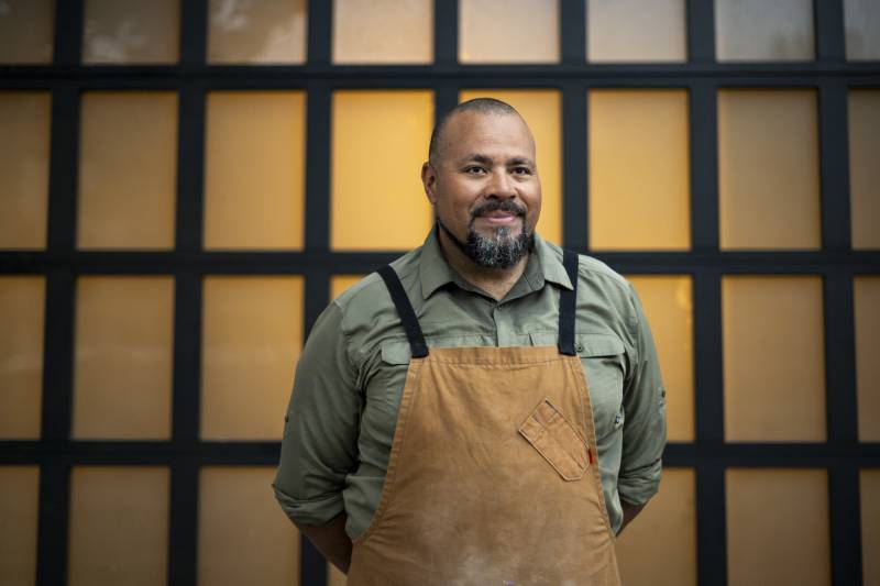 A person with a goatee and wearing an apron.