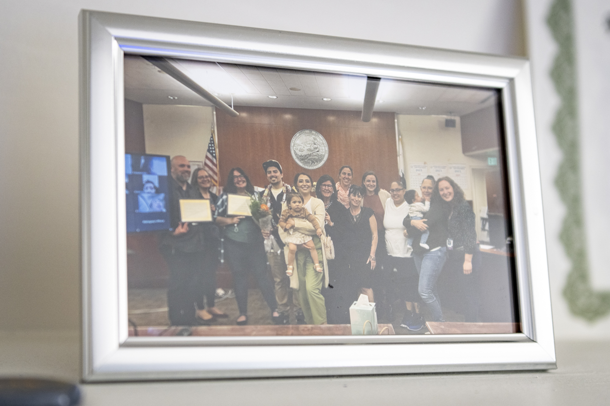 A framed photo of a group of people in an official looking setting.