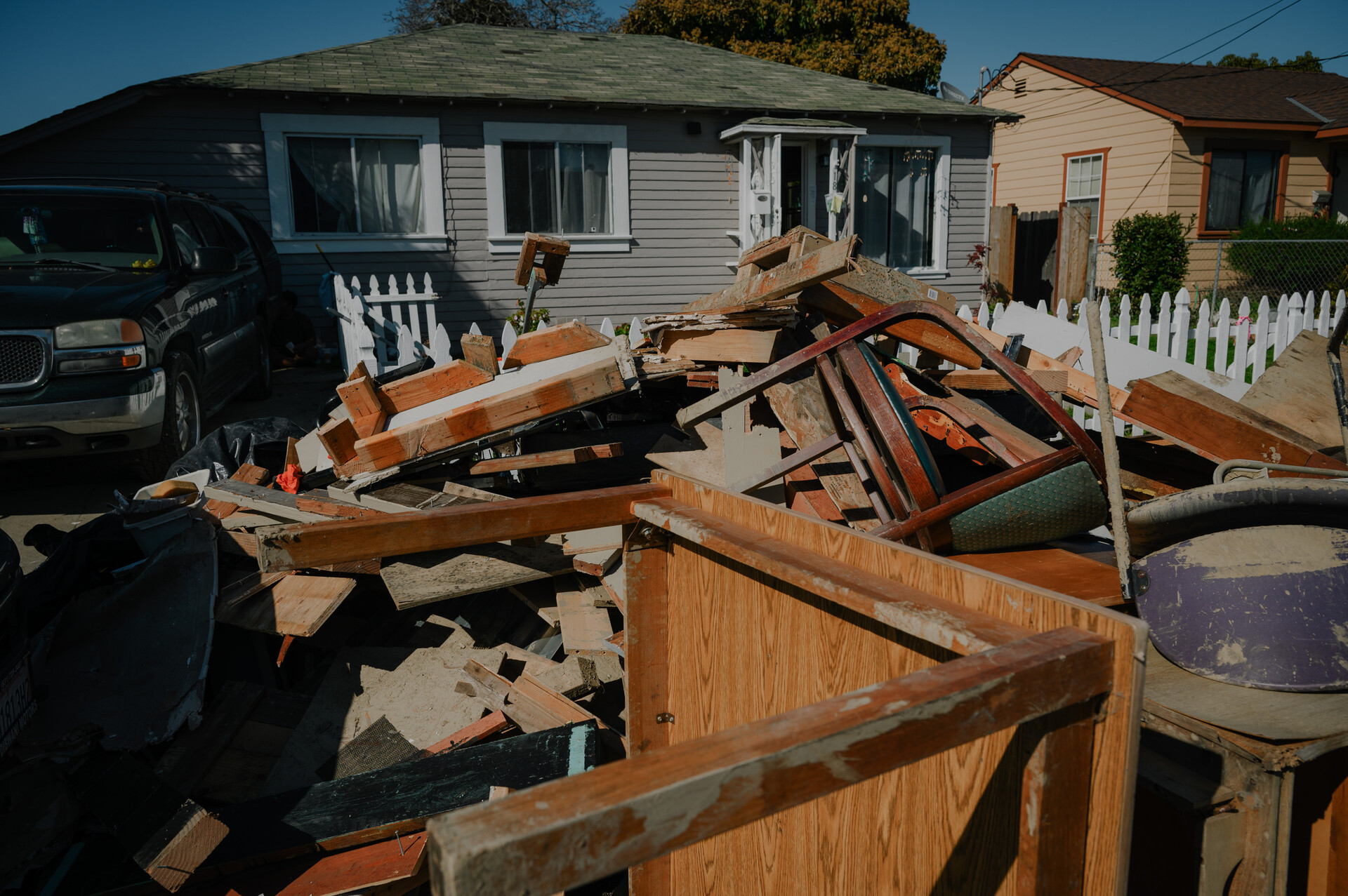 a pile of broken muddy furniture outside a house
