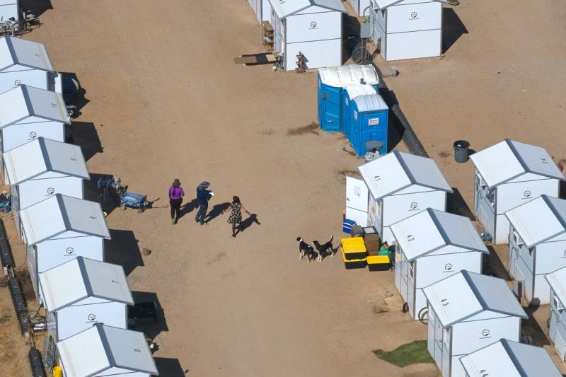 An aerial view of a housing site with a few people walking around.