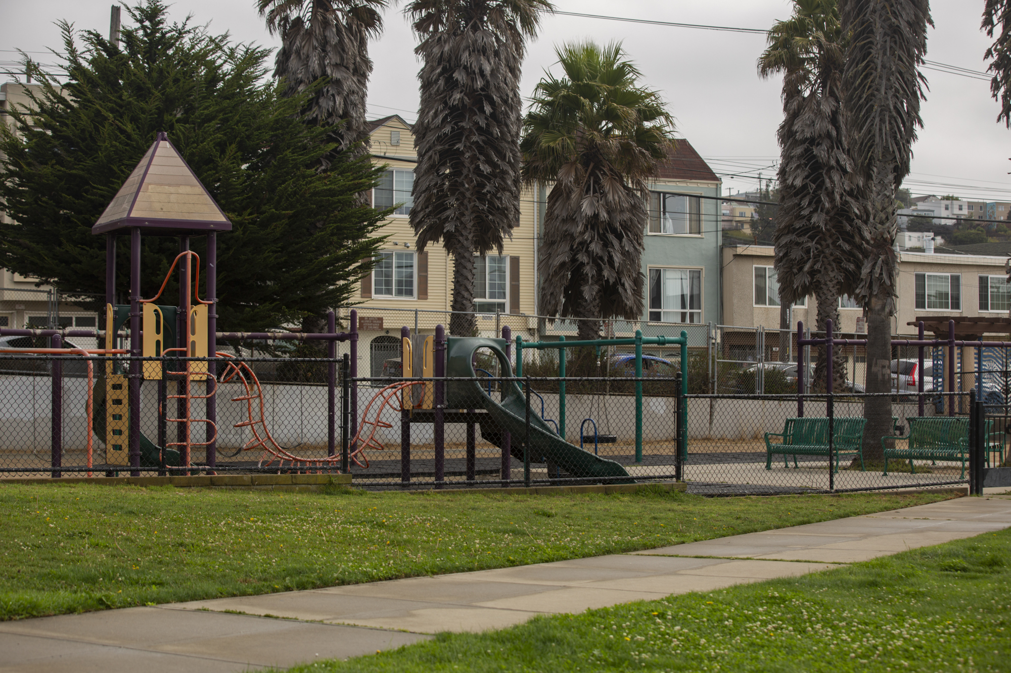 A play structure in a grassy park.