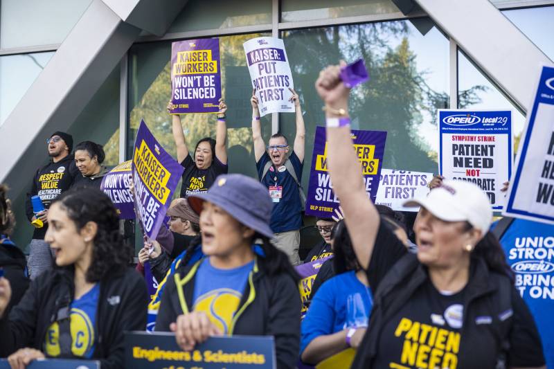 Kaiser workers on strike in front of a building.