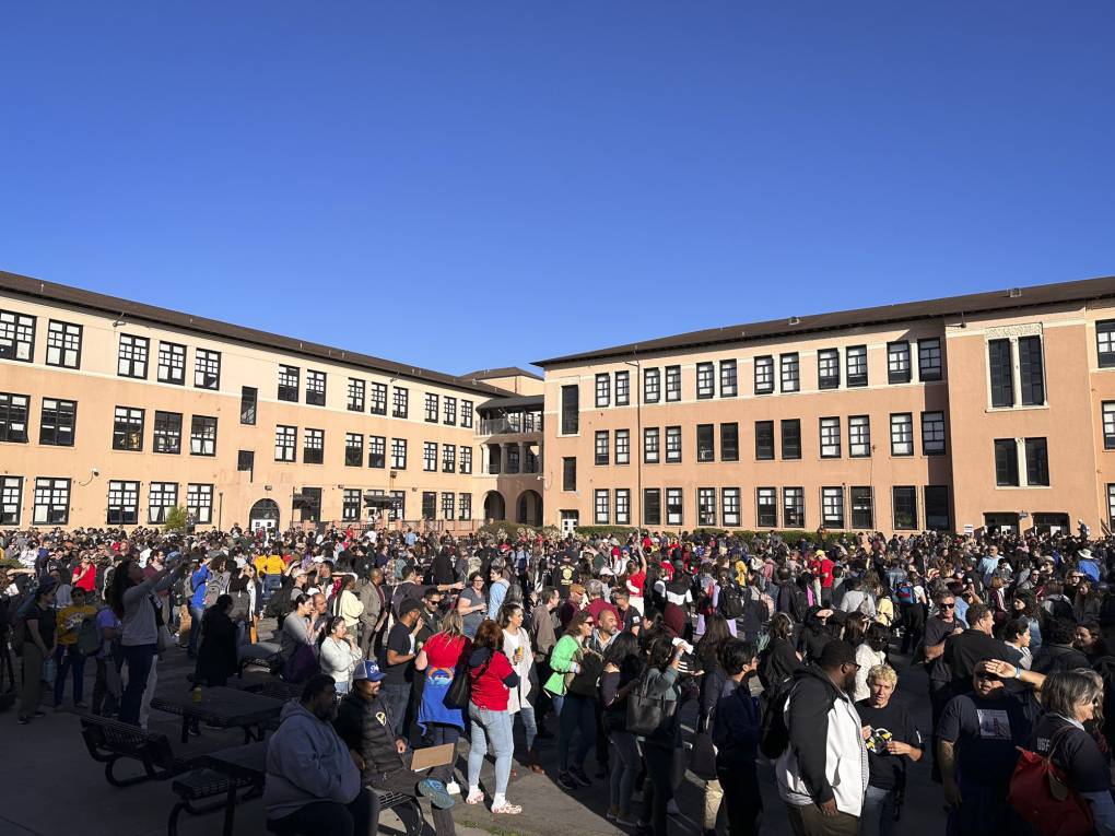 A large group of people assembled in an outdoor courtyard.