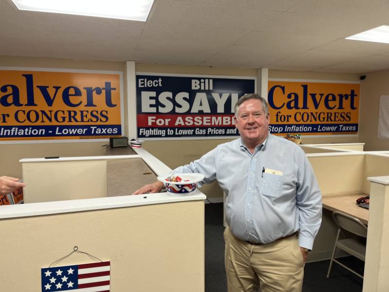a white man stands in a campaign office with signs reading 'Calvert for Congress'