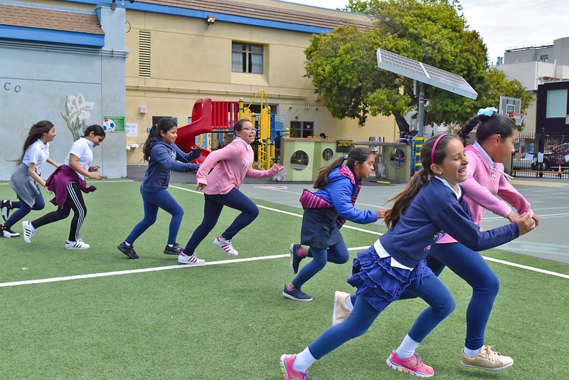 Children are playing at recess on the schoolgrounds.