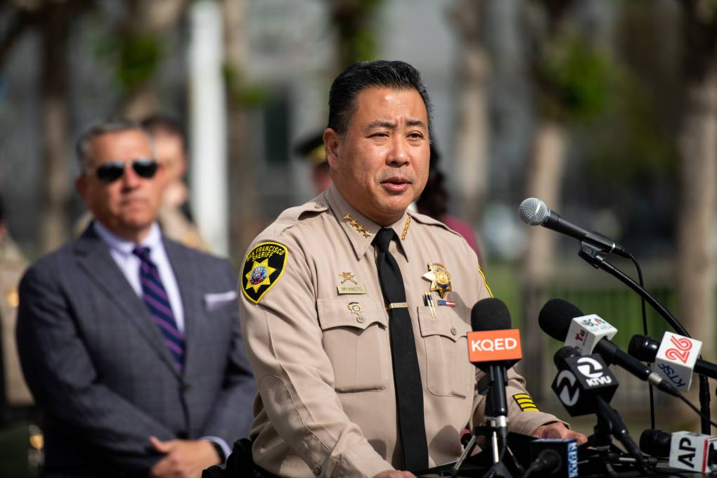 A sheriff in uniform speaks from a podium.
