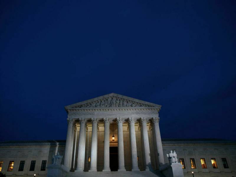 The front of the Supreme Court building with a blue sky in the background.