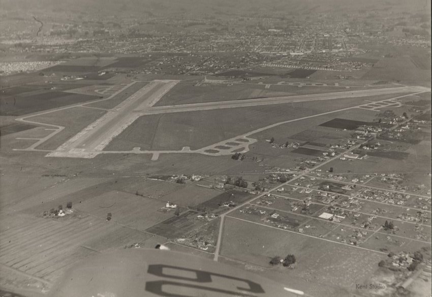 A black and white photograph of an airport and town.
