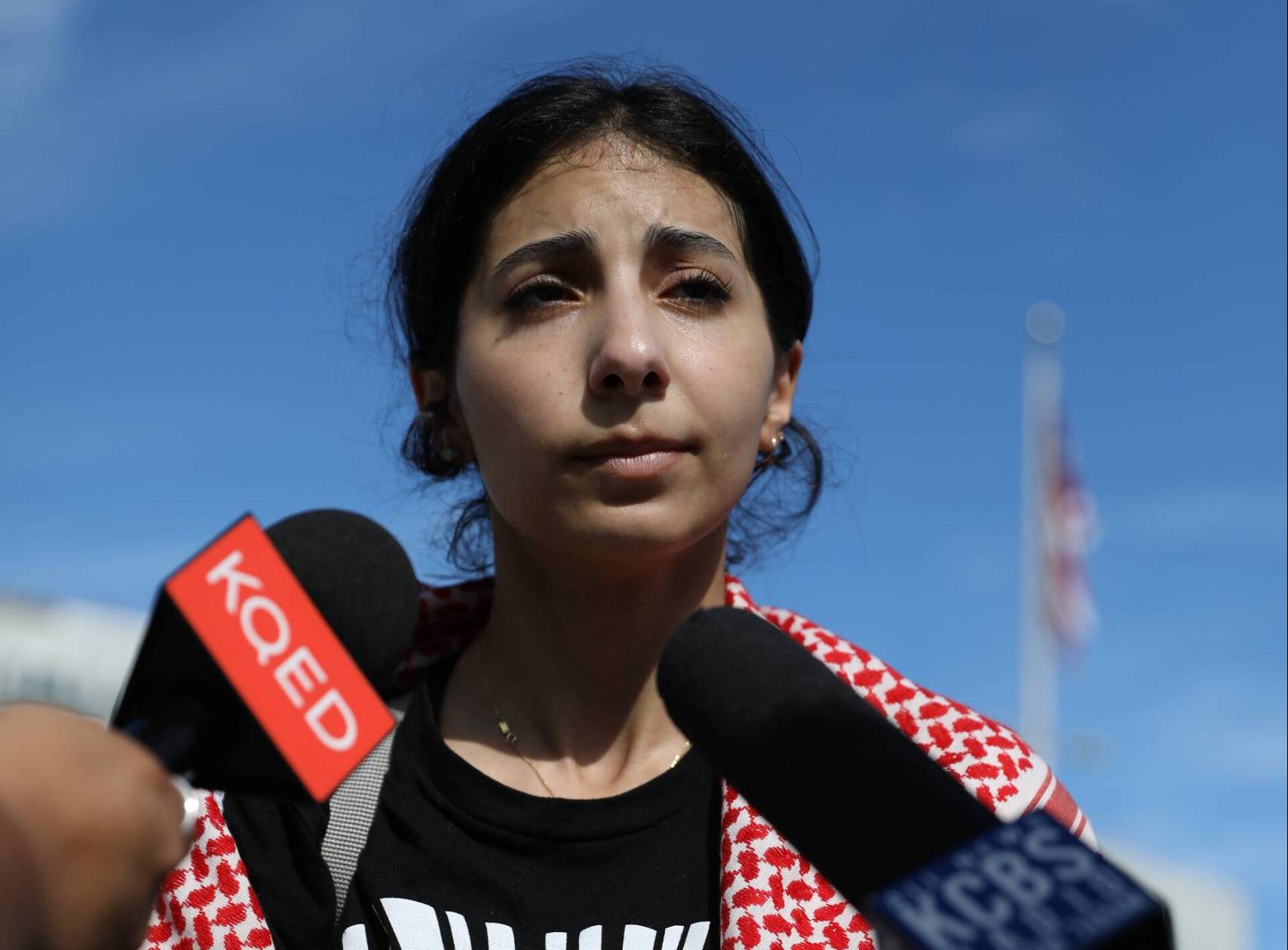 A young Palestinian-American woman speaks to reporters.
