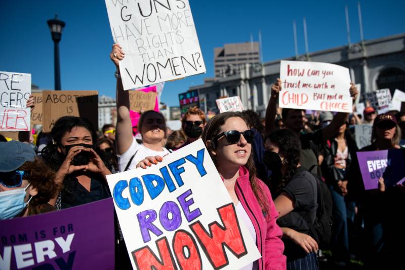 PRo-choice protesters at a rally in SF, holding signs. Oone sign says: 'Codify Roe Now.'