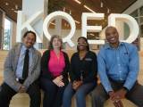 A portrait of KQED's Human Resources team seated shoulder to shoulder inside the lobby of KQED. From left to right, the image features Gabriel-John Ching, HR Generalist (Talent Acquisition); Adrianne Cabanatuan, Executive Director, Human Resources; Annette Spear-Jenkins, Human Resources Generalist; and Delano Garner, Organizational Talent Leader.