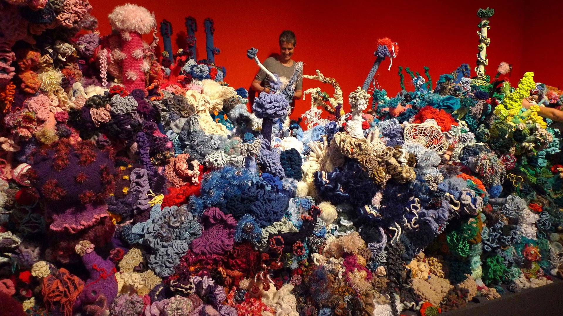 Margaret Wertheim, engulfed in the Föhr Reef, (Museum Kunst der Westküste, Föhr, Germany, 2012). A similar exhibition she co-created, called The Crochet Coral Reef, is on view the Mary Porter Sesnon Art Gallery at UC Santa Cruz.  Photo: Courtesy of Steve Kurtz