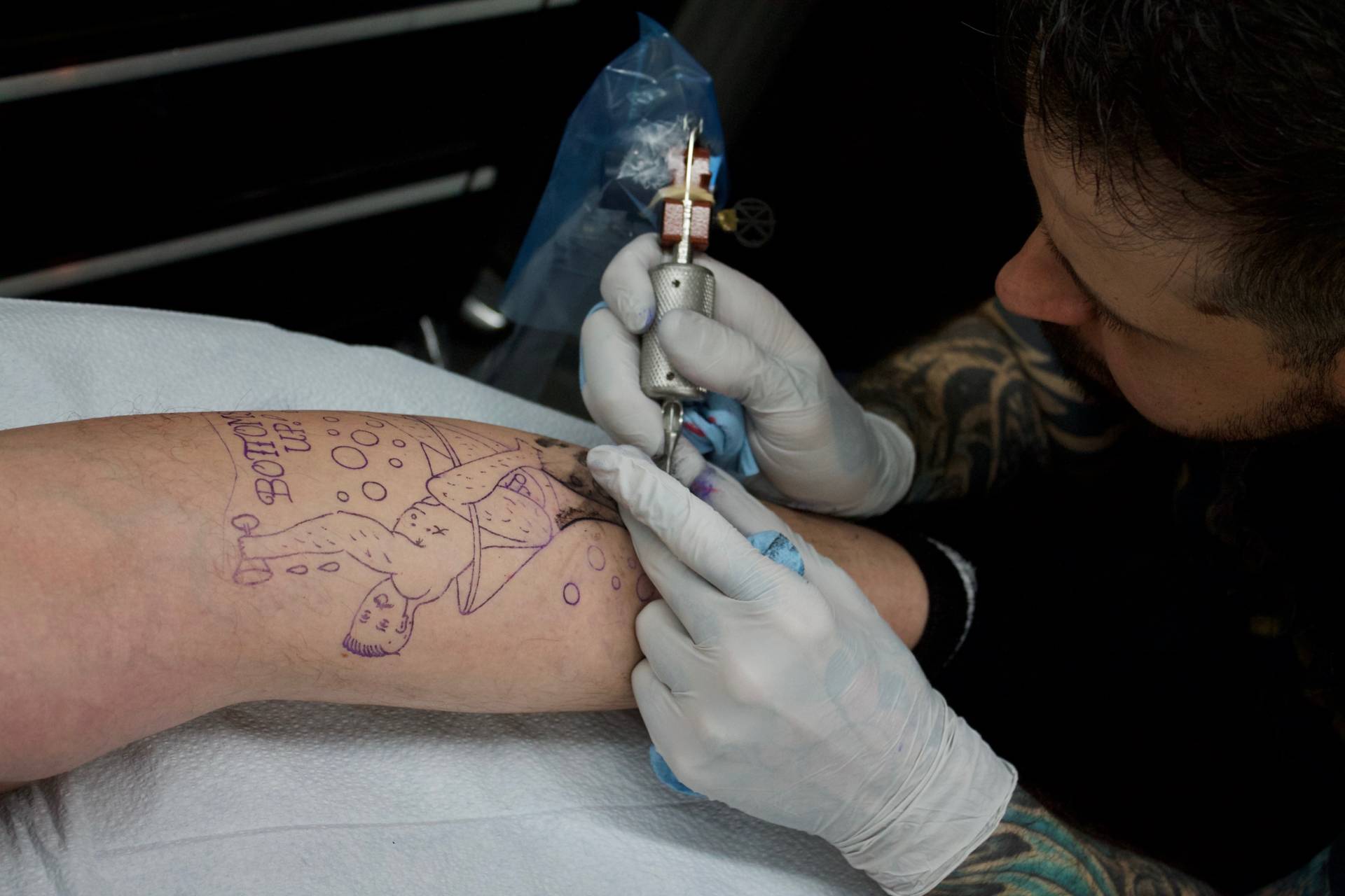 Nick Bergin, owner of Godspeed Tattoo, works on a male pin-up design in San Mateo, California on Nov. 14, 2017. Audrey Garces/KQED