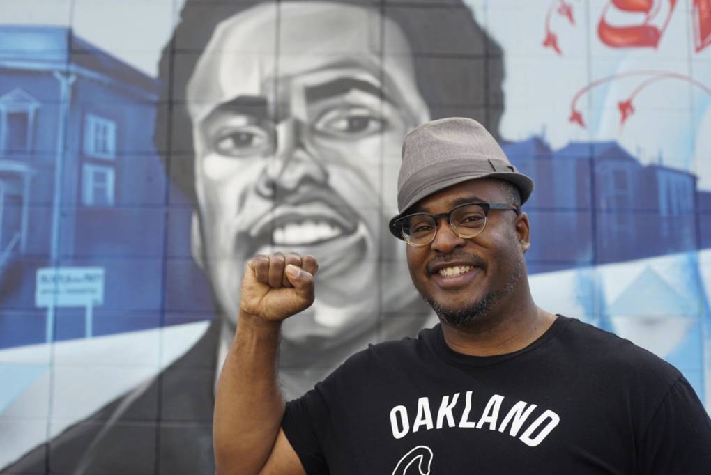 Artist Refa One with his mural honoring Huey Newton at 14th and Peralta in West Oakland.