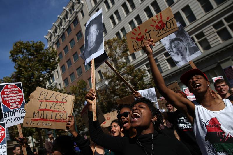 Protesters hold signs during a demonstration against police brutality on Oct. 22, 2014 in Oakland, California. 