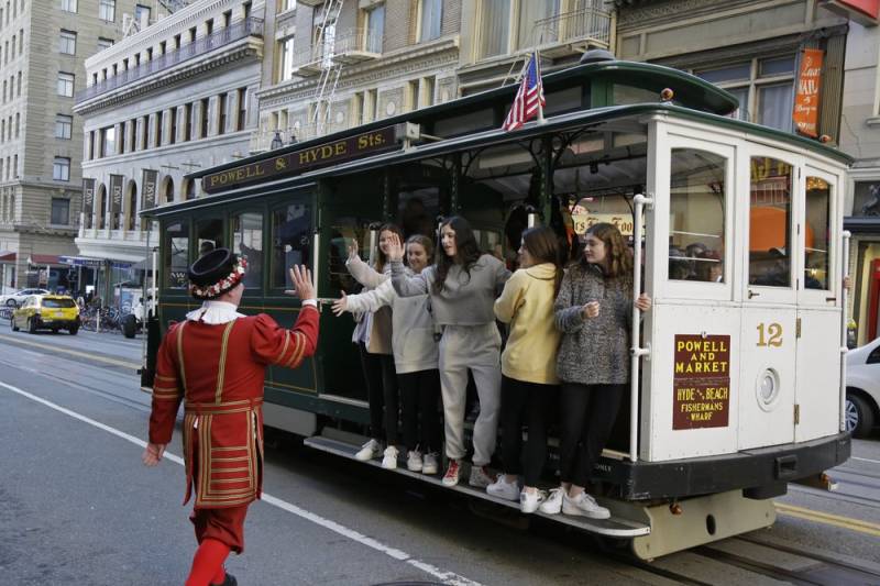 Sweeney greets a group of girls riding a cable car outside the Sir Francis Drake Hotel. 