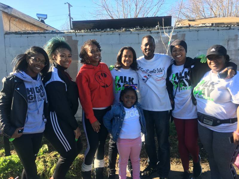 Khariyyah Shabazz(red sweatshirt) poses with employees, parents and students at the 2019 MLK Day of service. 
