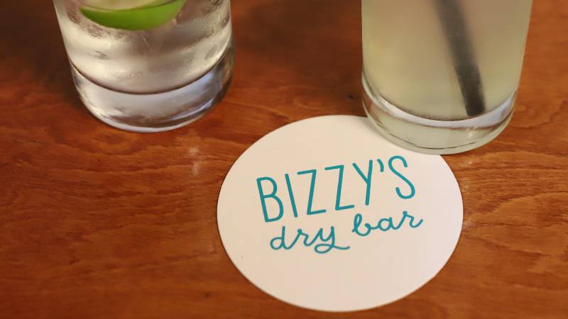 Two drinks and a coaster that says "Bizzy's Dry Bar."
