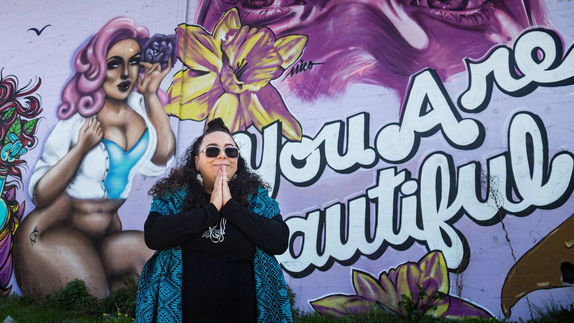 DJ Agana in front of the 'You Are Beautiful' mural in West Oakland. <a href="https://www.instagram.com/carla.hr/" target="_blank">Carla Hernandez Ramirez</a>