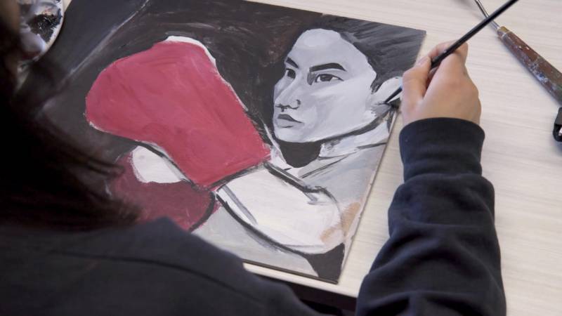 Kathy Liang painting an image of herself boxing