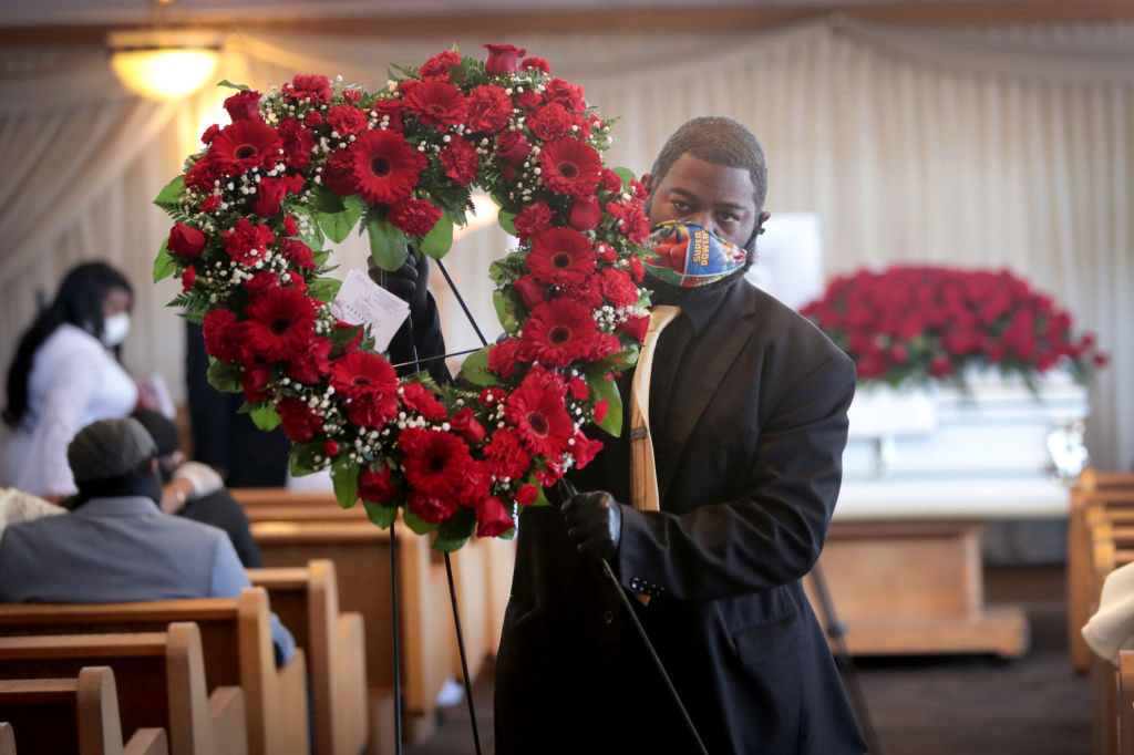 Terrence Bardney of Leak and Sons' Funeral Chapels carries flowers from the chapel following a service on April 16, 2020 in Country Club Hills, Illinois.