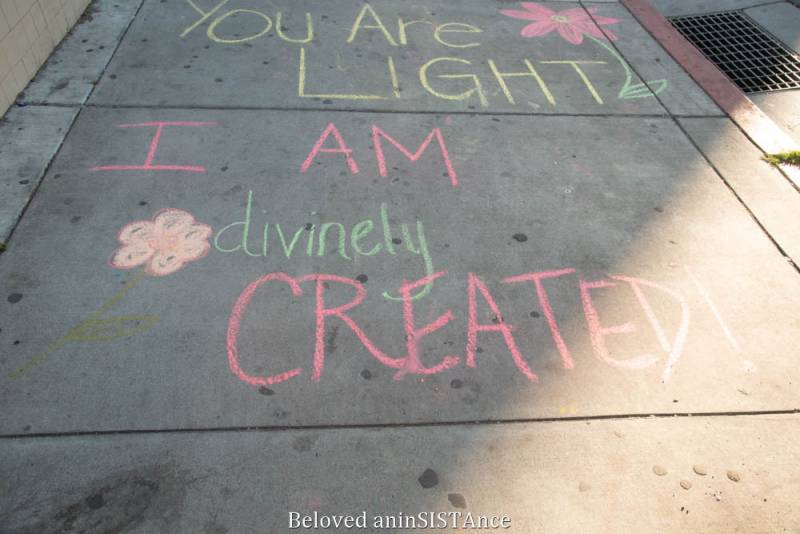 "You Are LIGHT" and "I AM divinely CREATED" written in chalk on the sidewalk. 